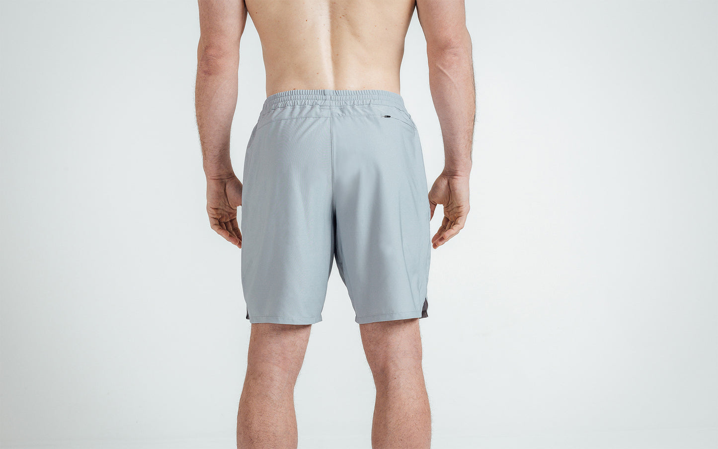 Athlete wearing Silver Men's Motus Shorts, back view