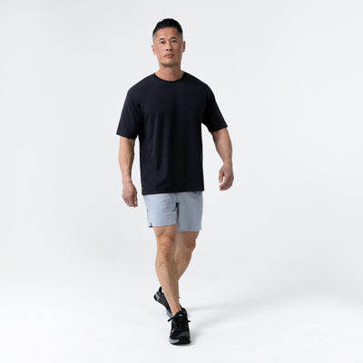 Men's Magnis Heavyweight T-Shirt in Black on person with grey shorts on a white background