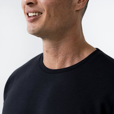 Men's Magnis Heavyweight T-Shirt in Black on person . Close-up of neck line