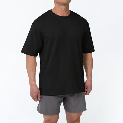 Men's Magnis Heavyweight T-Shirt in Black on person with grey shorts on a white background