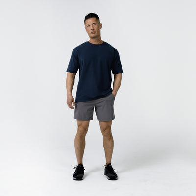 Men's Magnis Heavyweight T-Shirt in Navy on person with grey shorts on a white background