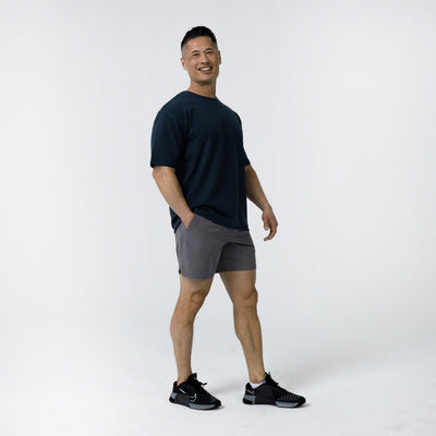 Men's Magnis Heavyweight T-Shirt in Navy on person with grey shorts on a white background