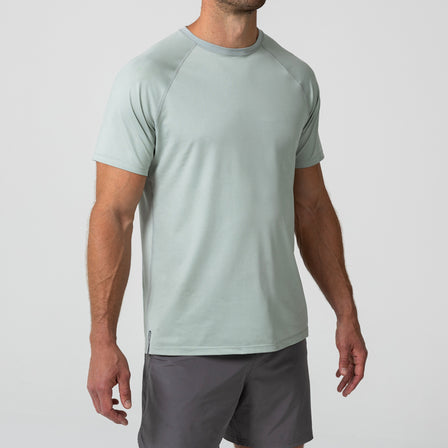 Person wearing an Aqua Gray Men's Aerix athletic shirt and shorts on a white background