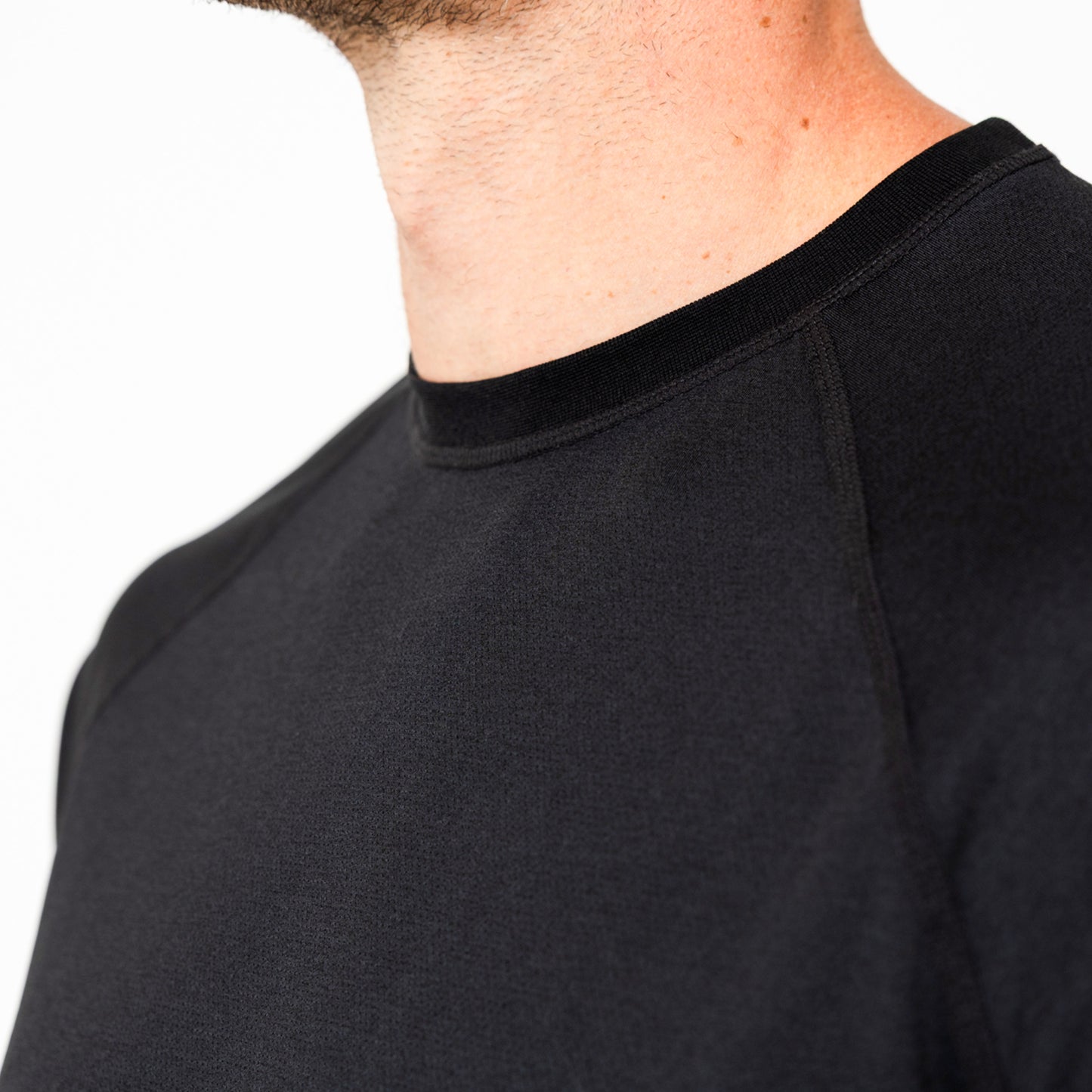Close-up of a person wearing a black Men's Aerix shirt on a white background