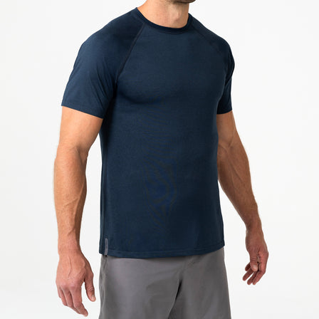 Person wearing a navy Men's Aerix athletic shirt and shorts on a white background