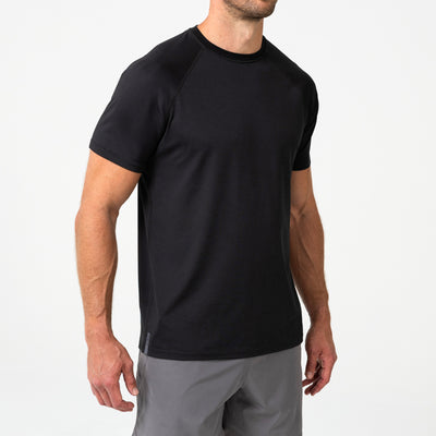 Person wearing a black Men's Aerix athletic shirt and shorts on a white background