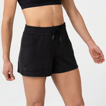 Person wearing black Women's Vellus athletic shorts on a plain background