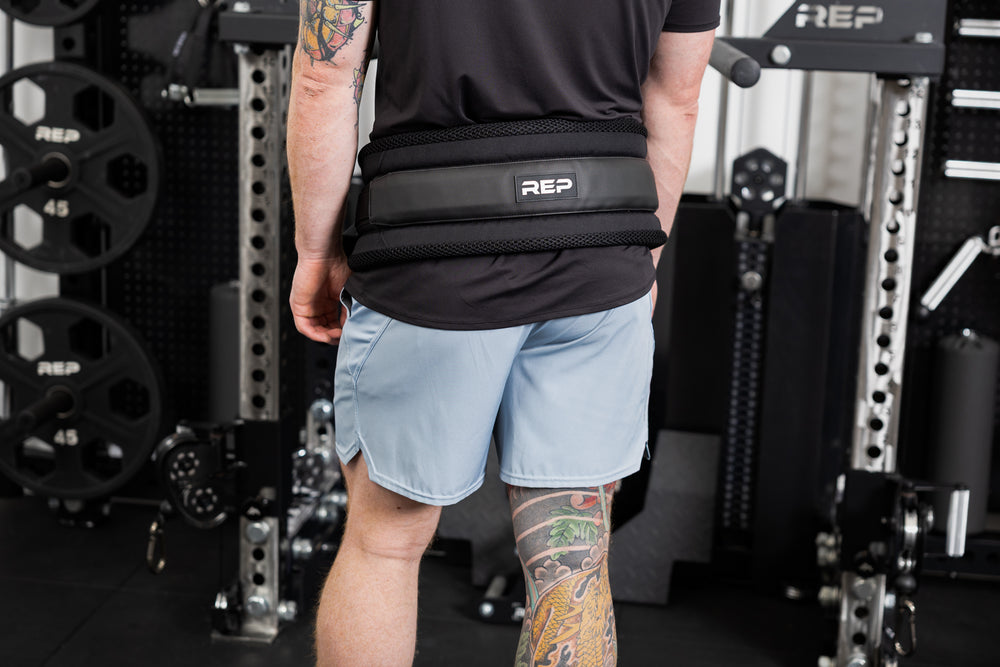 Person wearing the belt squat belt and showing the REP logo on the back 