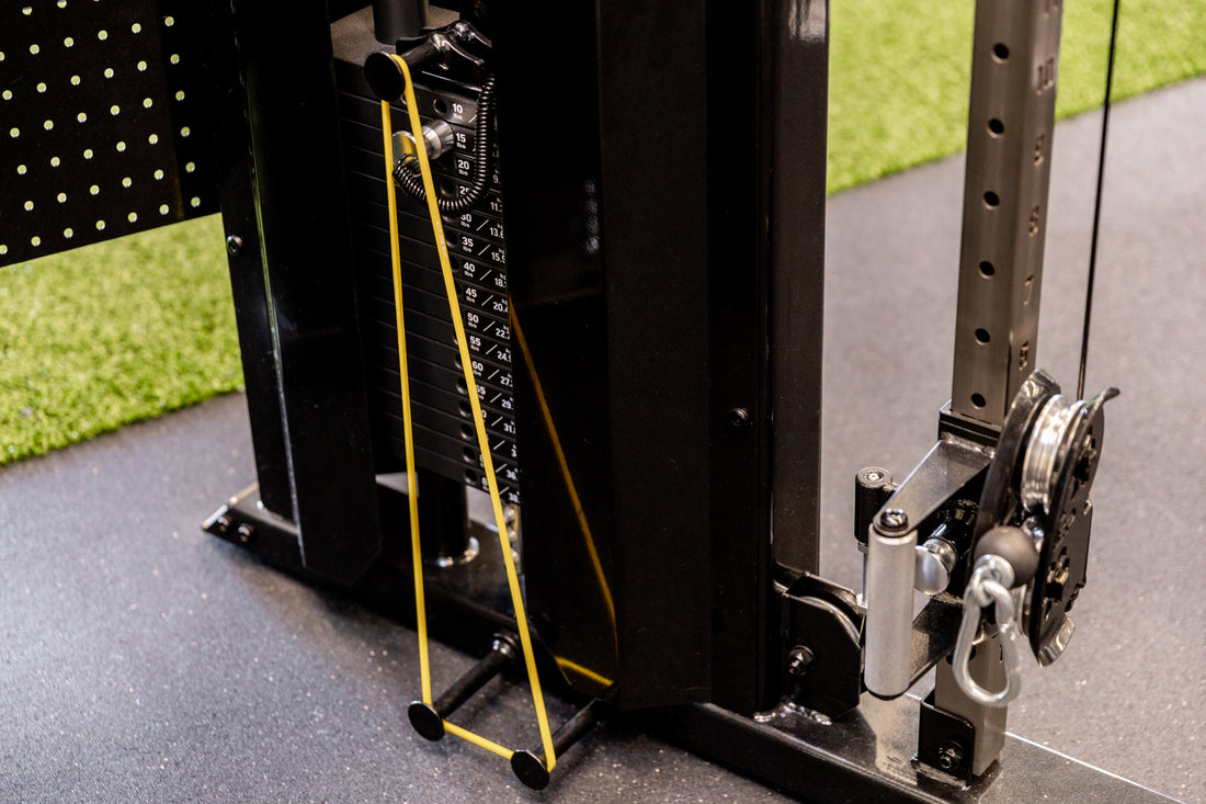 Yellow short resistance bands attached to the band pegs of the REP Arcadia Functional Trainer for added resistance.