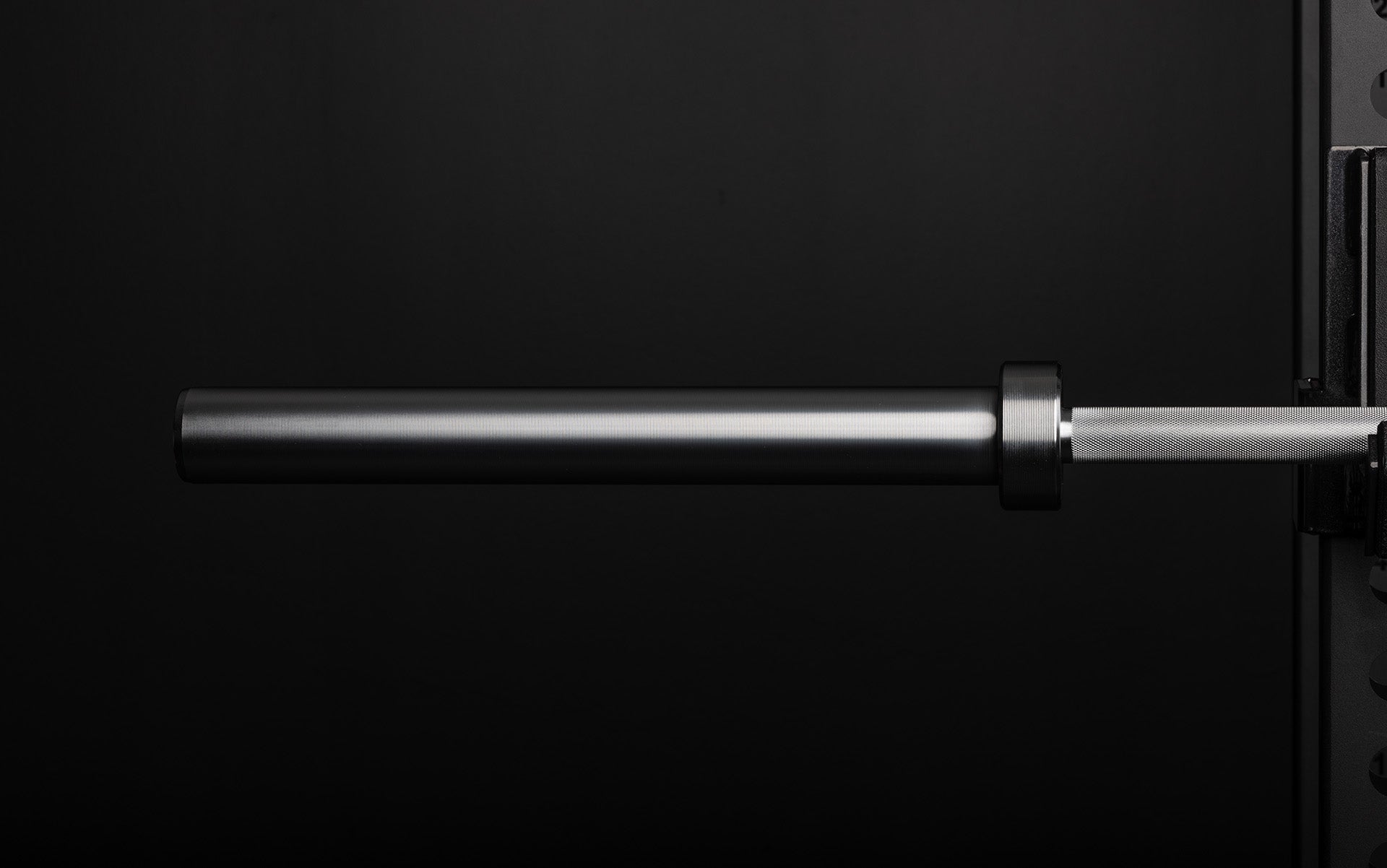 Close-up view of the ribbed sleeve of a racked REP 20kg Alpine Weightlifting Bar.