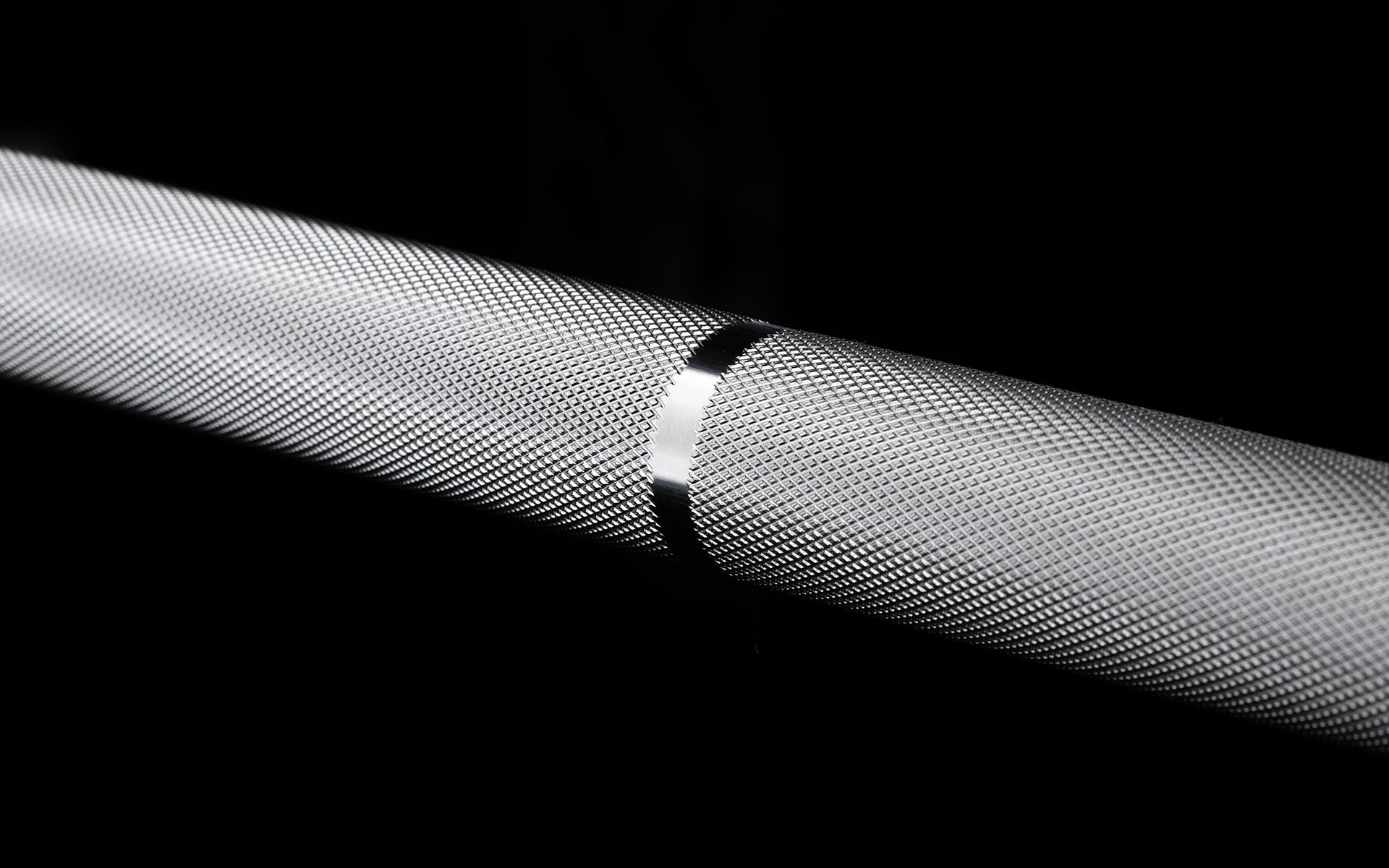 Close-up view of the medium depth knurling and an IWF knurling mark on the REP 20kg Alpine Weightlifting Bar.