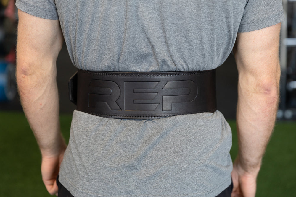 Athlete putting on the black REP Premium Leather Lifting Belt.