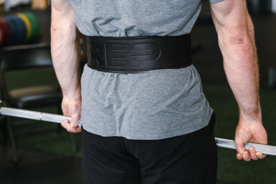 Athlete performing a deadlift while wearing a black REP Premium Leather Lifting Belt.