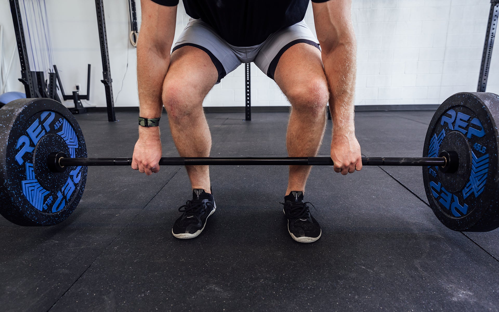 Close-up view of a male lifter performing a deadlift with a loaded REP Black Canyon Bar - 20kg.