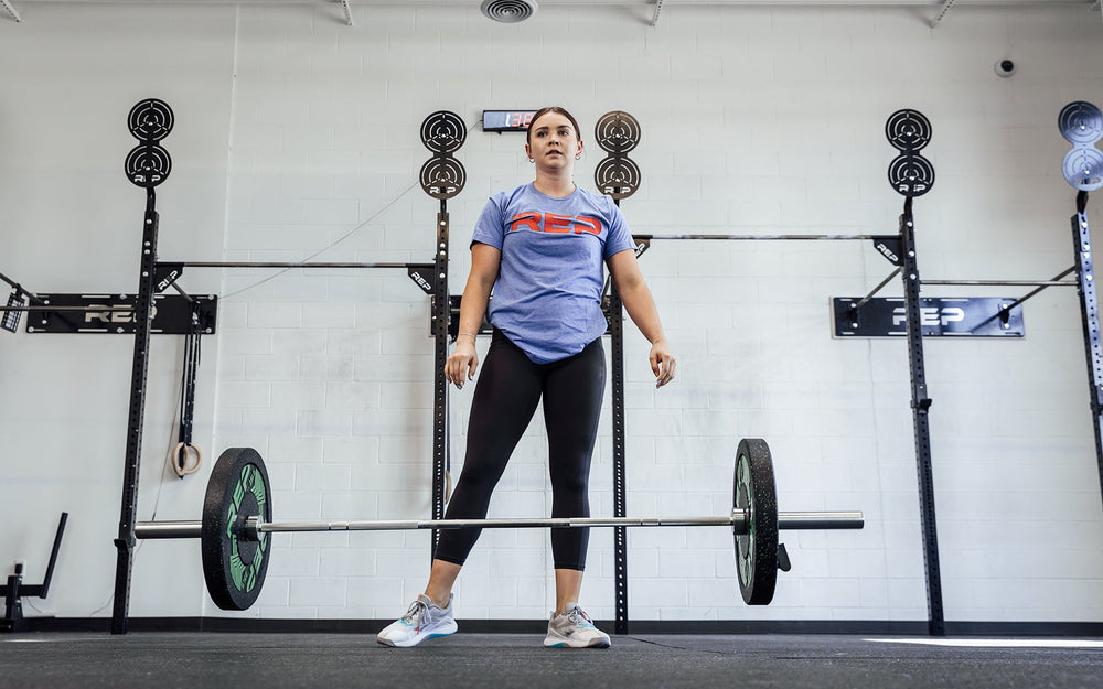 Female lifter having just dropped a loaded REP 15kg Black Canyon Bar after performing a snatch.