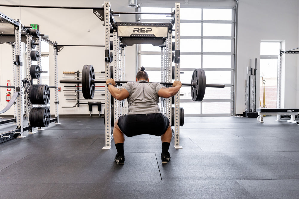 Lifter performing a back squat using a Black Diamond Power Bar.