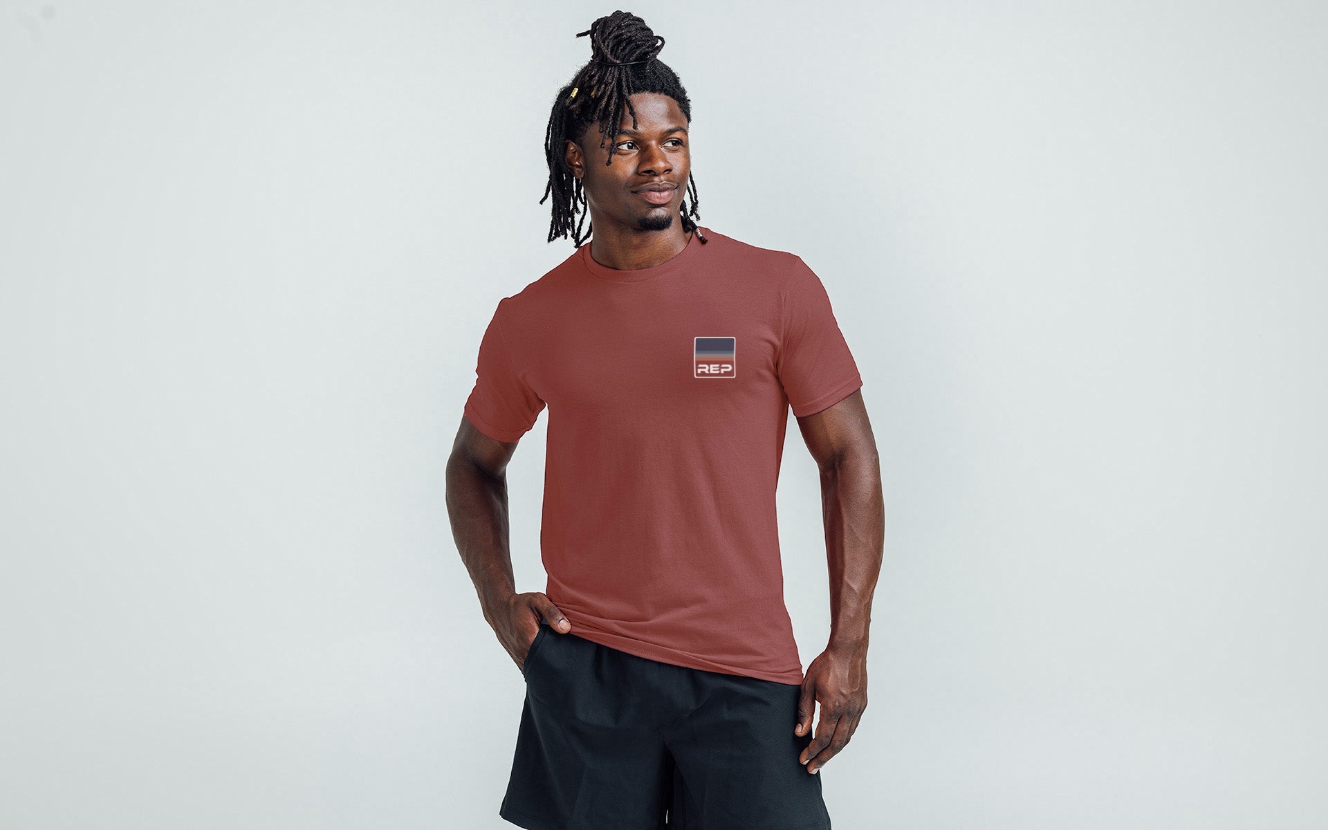 An athlete wearing the REP Fitness Rise Tri-Blend Crew T-Shirt in Heather Olive and Red