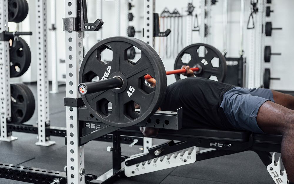 Male lifter performing a bench press with a loaded REP 20kg Colorado Bar.