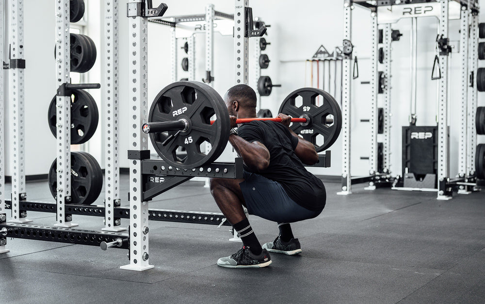 Male lifter performing a back squat with a loaded 20kg Colorado Bar.