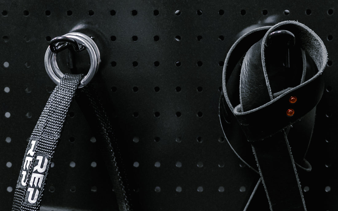 Close up of accessories hanging on pegboard storage hooks.