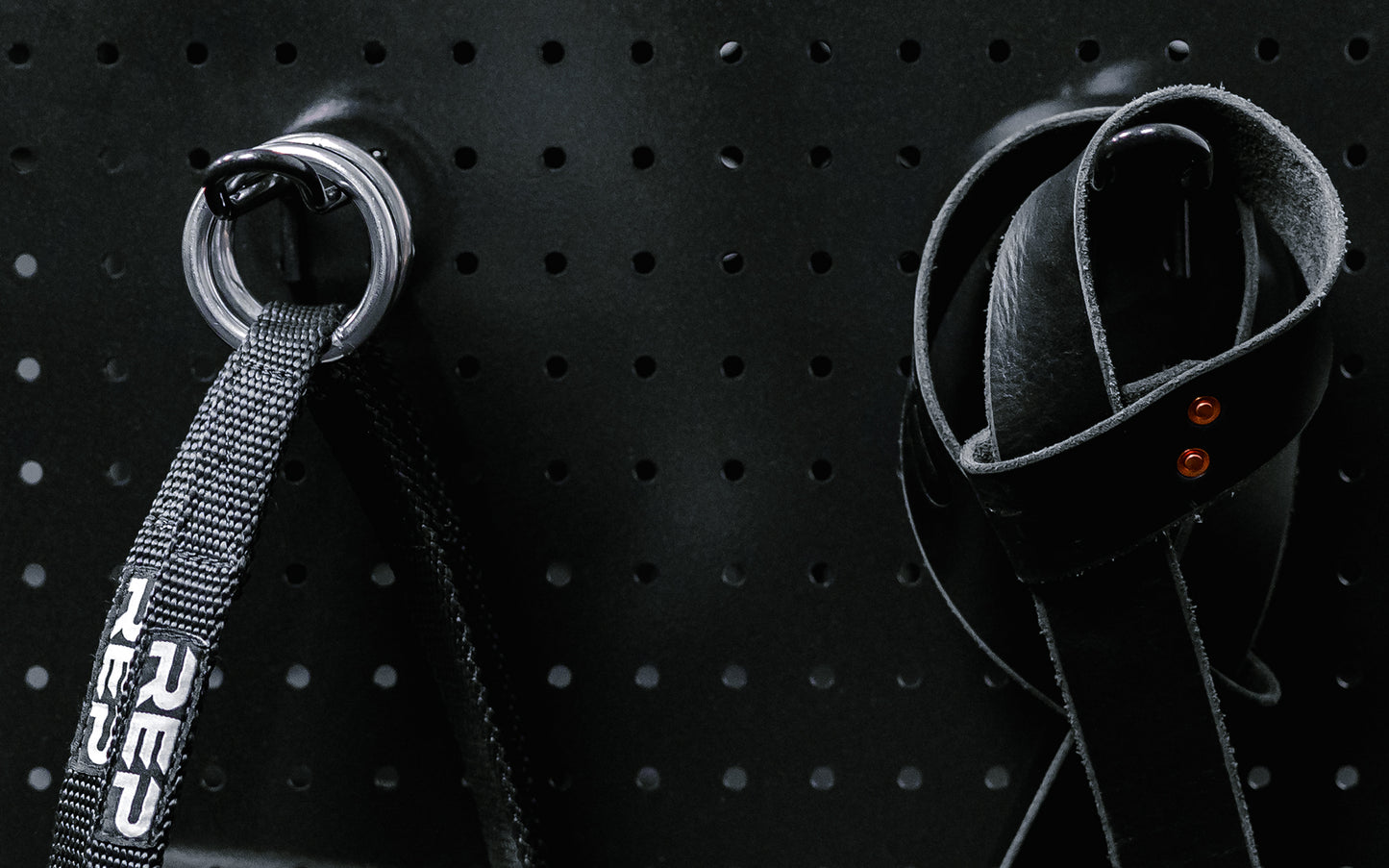 Close up of accessories hanging on pegboard storage hooks.