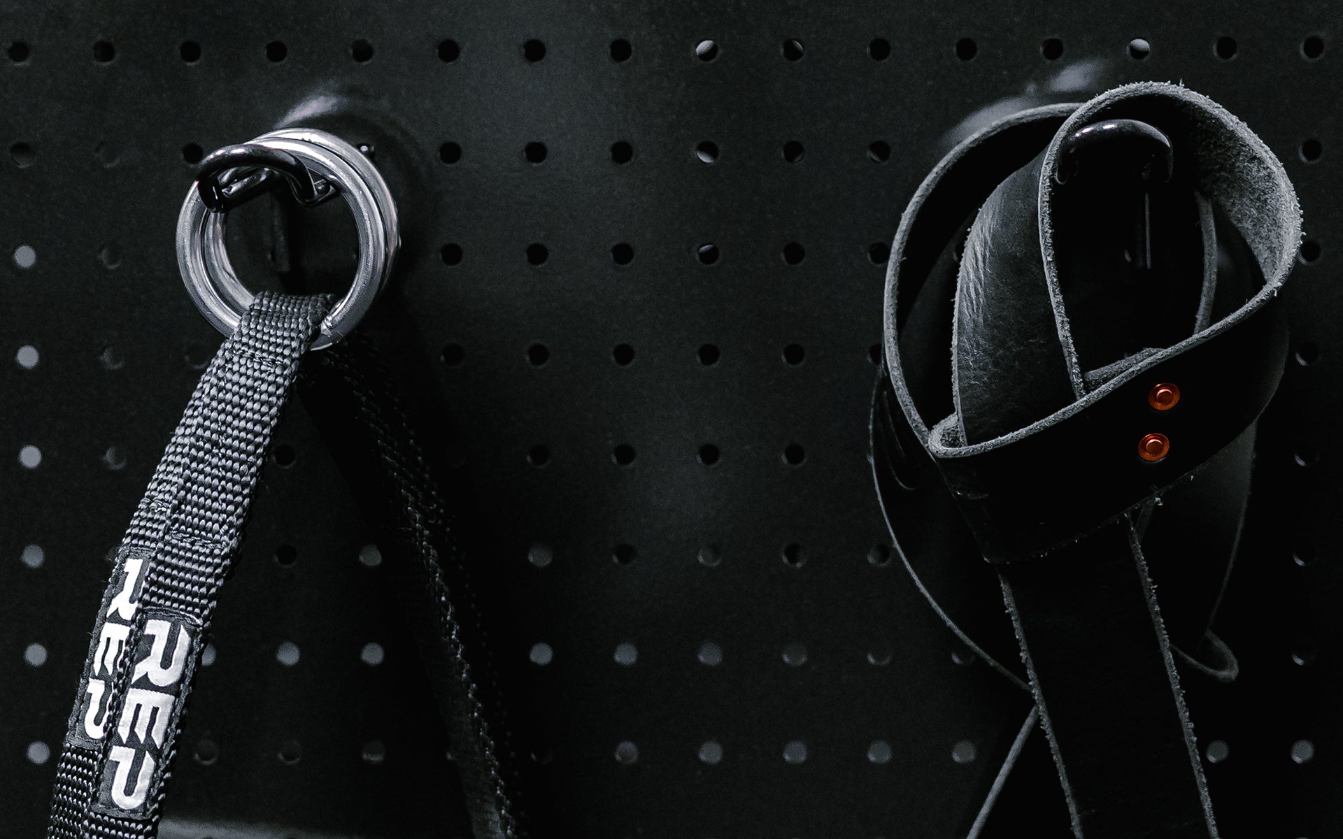 Close up of accessories hanging on pegboard storage hooks.