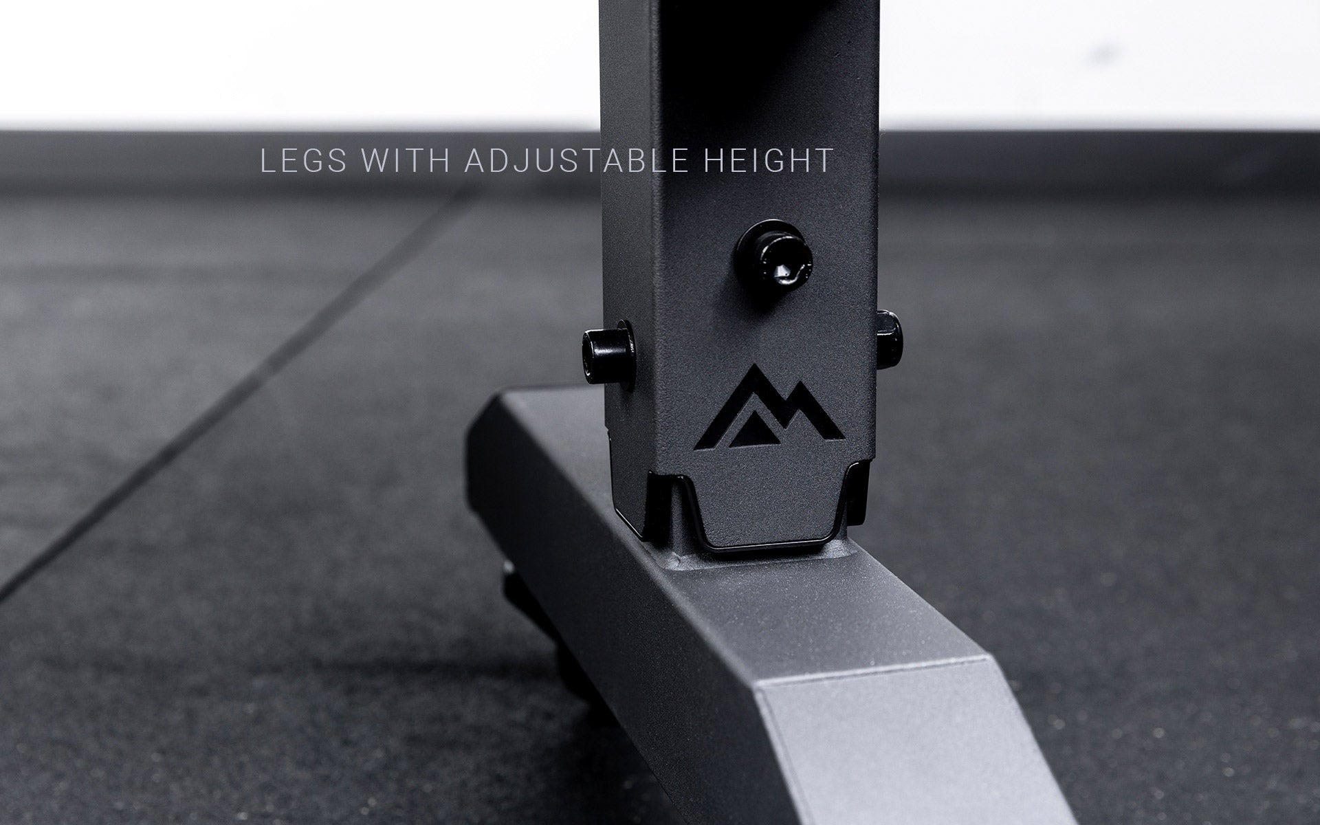 Legs featuring a laser cut mountain logo on the matte black REP® Adjustable Dumbbell Stand. Text says 