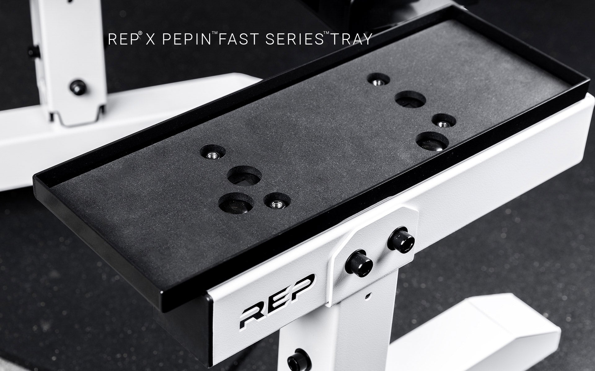 Black trays for REP® x PÉPIN™ adjustable dumbbells on a white REP® Adjustable Dumbbell Stand