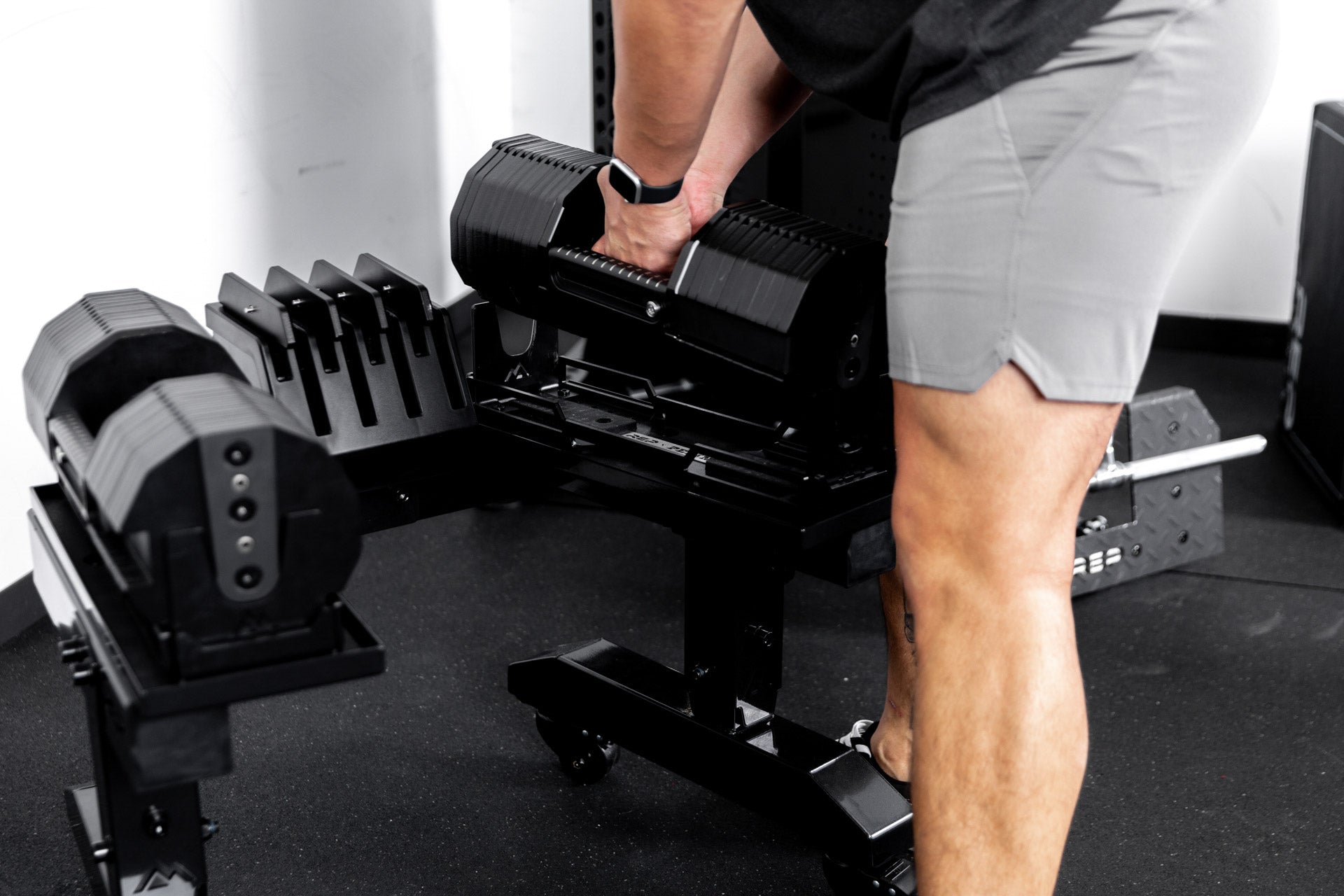 Athlete removing the REP x PÉPIN FAST Series Adjustable Dumbbell from the Adjustable Dumbbell Stand.