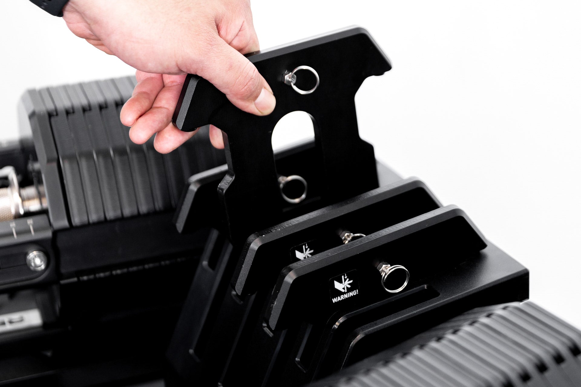 Athlete putting REP® x PÉPIN™ add-on weights back into the attached add-on weight holder.