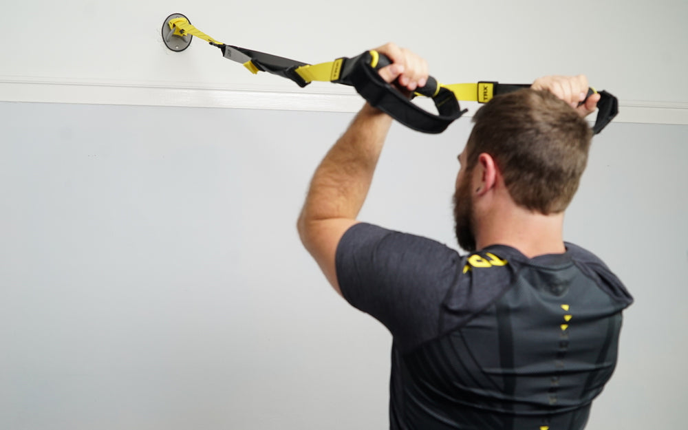 Action shot: Athlete working out on a TRX Suspension Trainer™ attached to a TRX X-Mount® on a home wall