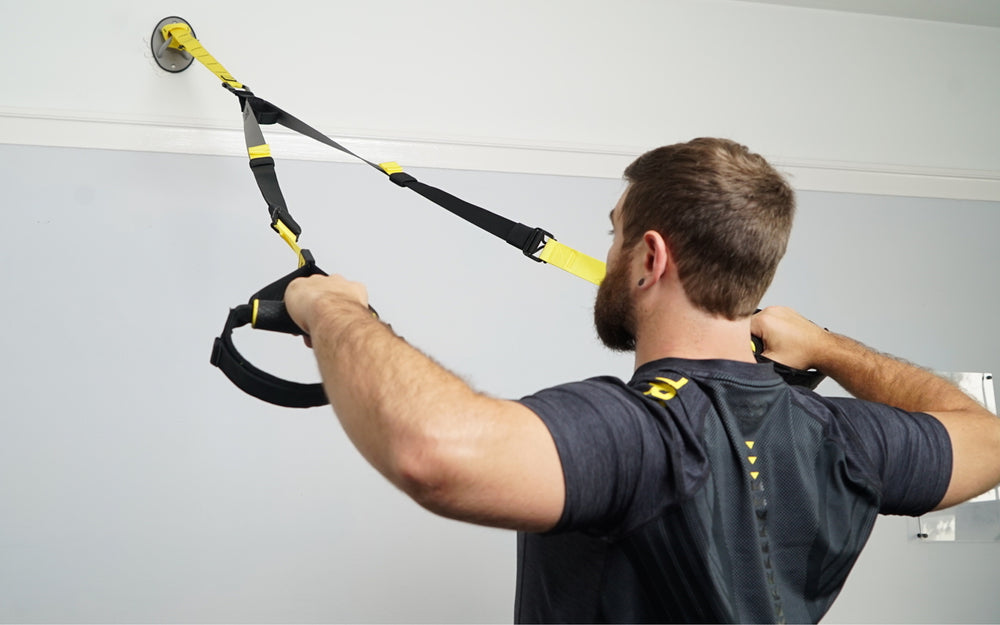 Action shot: Athlete using a TRX Suspension Trainer™ attached to a TRX X-Mount® on a home wall