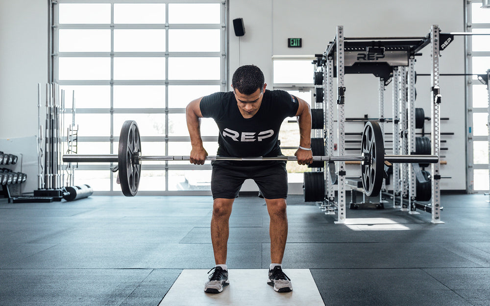 Male lifter performing a bent over row with a loaded REP Delta Basic Bar.