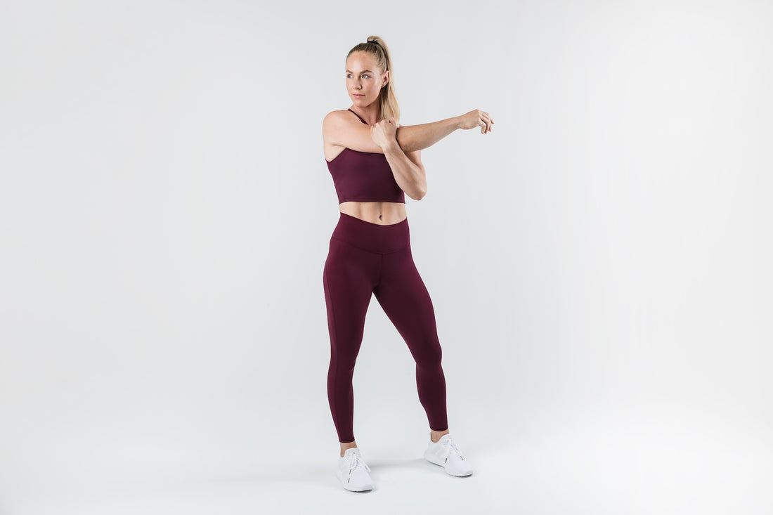 The REP Fitness Women's Eos Legging in Wine front, stretching