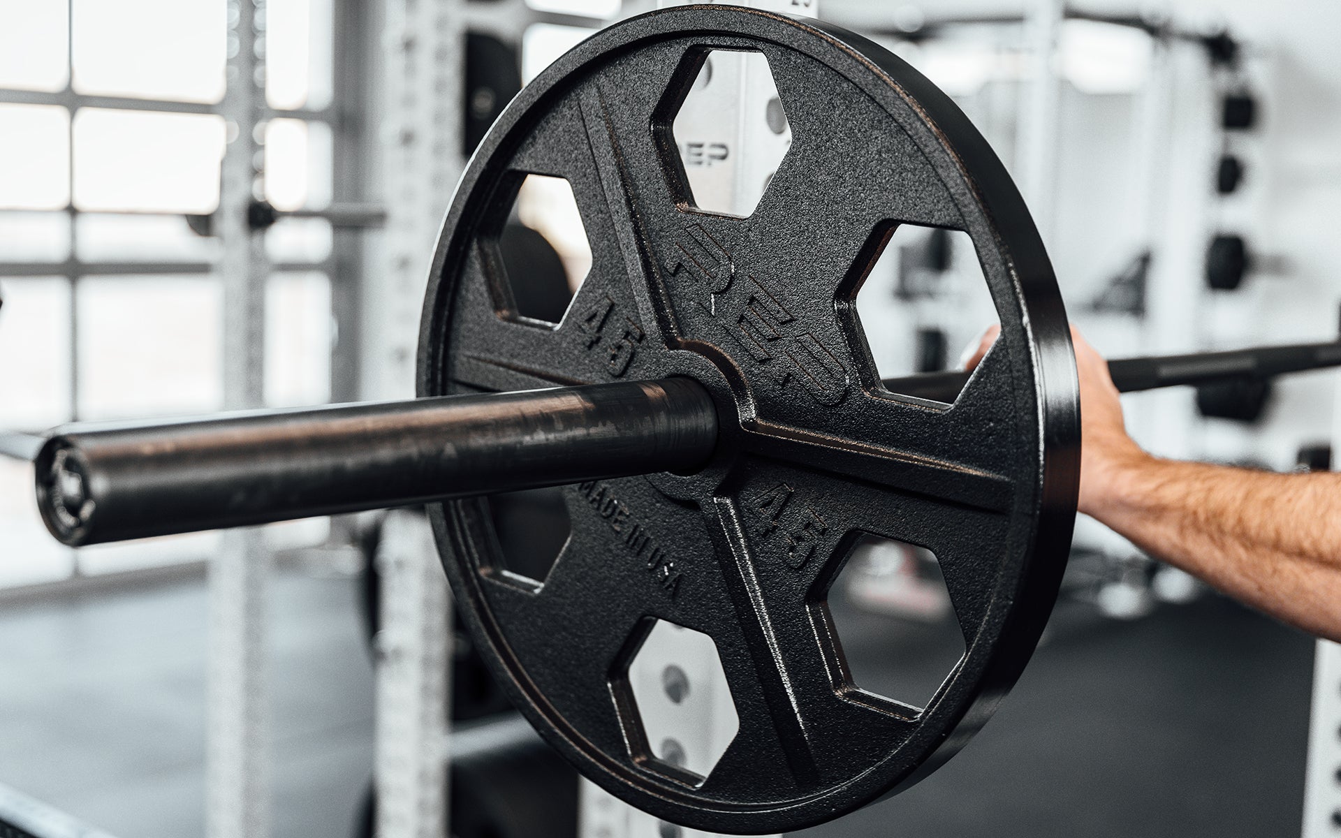 Close-up view of a 45lb USA-Made Equalizer Iron Plate loaded on a racked barbell.