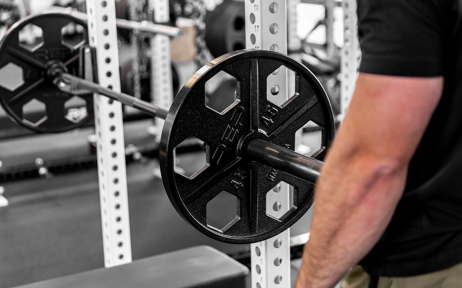 A racked barbell loaded with a pair of 45lb USA-Made Equalizer Iron Plates.
