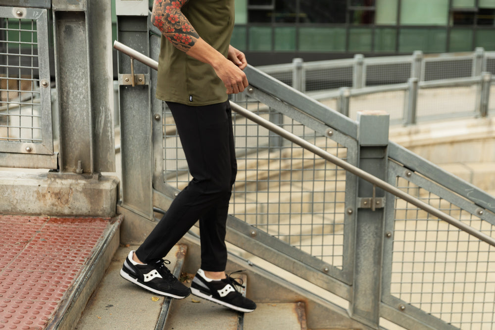 Athlete walking down steps wearing the Men's Felix Pants 2.0 in black