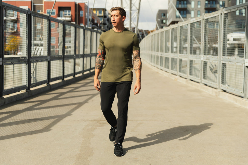 Athlete walking in the city wearing the black Men's Felix Pants 2.0