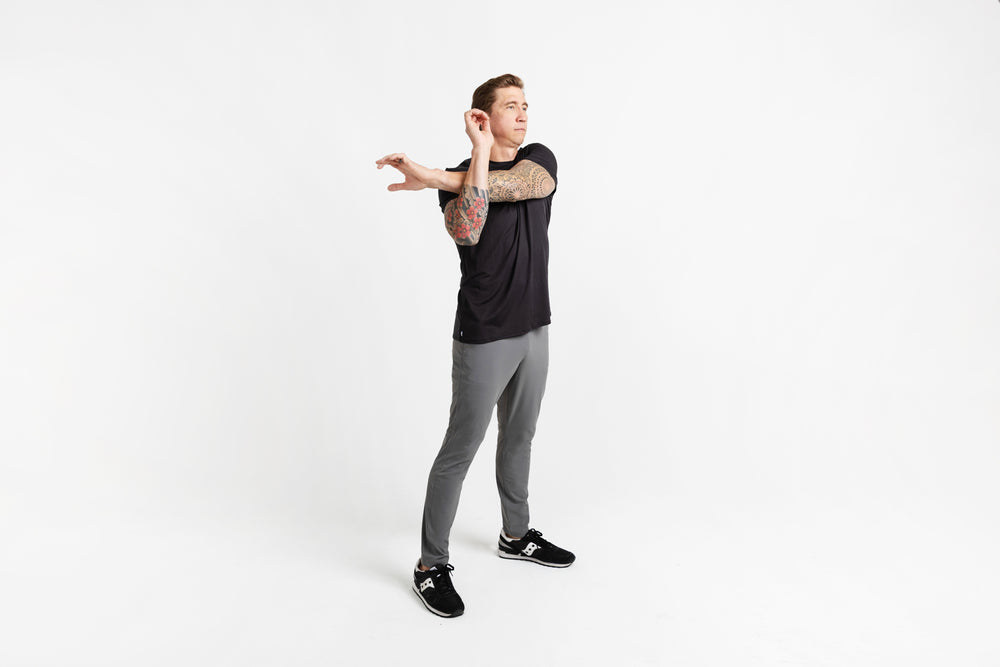 Side shot of an athlete stretching in grey Men's Felix Pants 2.0