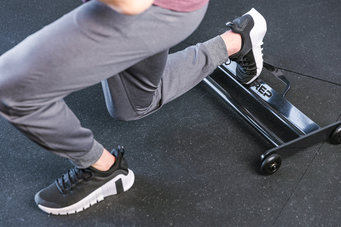 Athlete with 1 foot on the glute ham roller