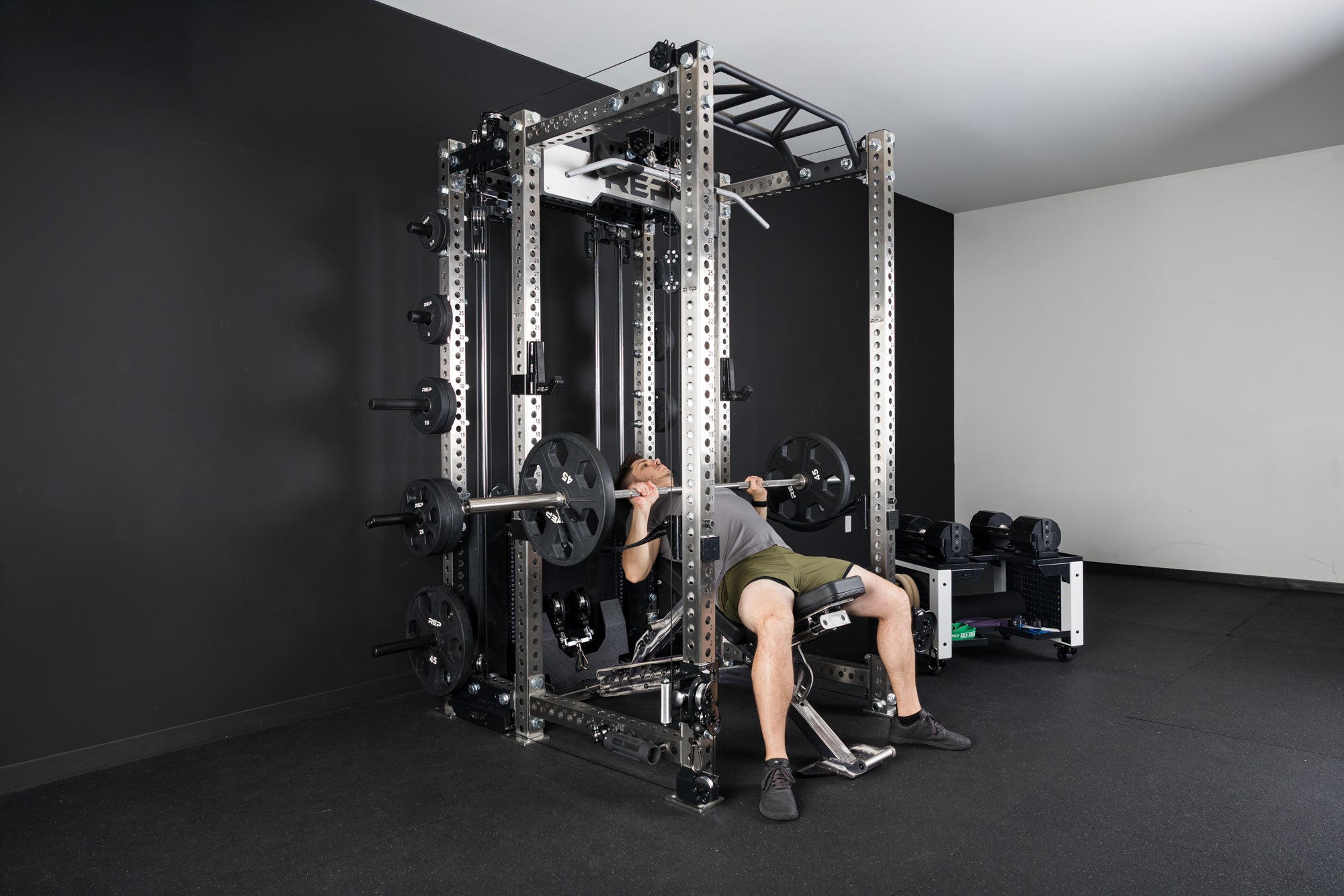 An athlete incline bench pressing inside the PR-5000 rack on a BlackWing adjustable bench