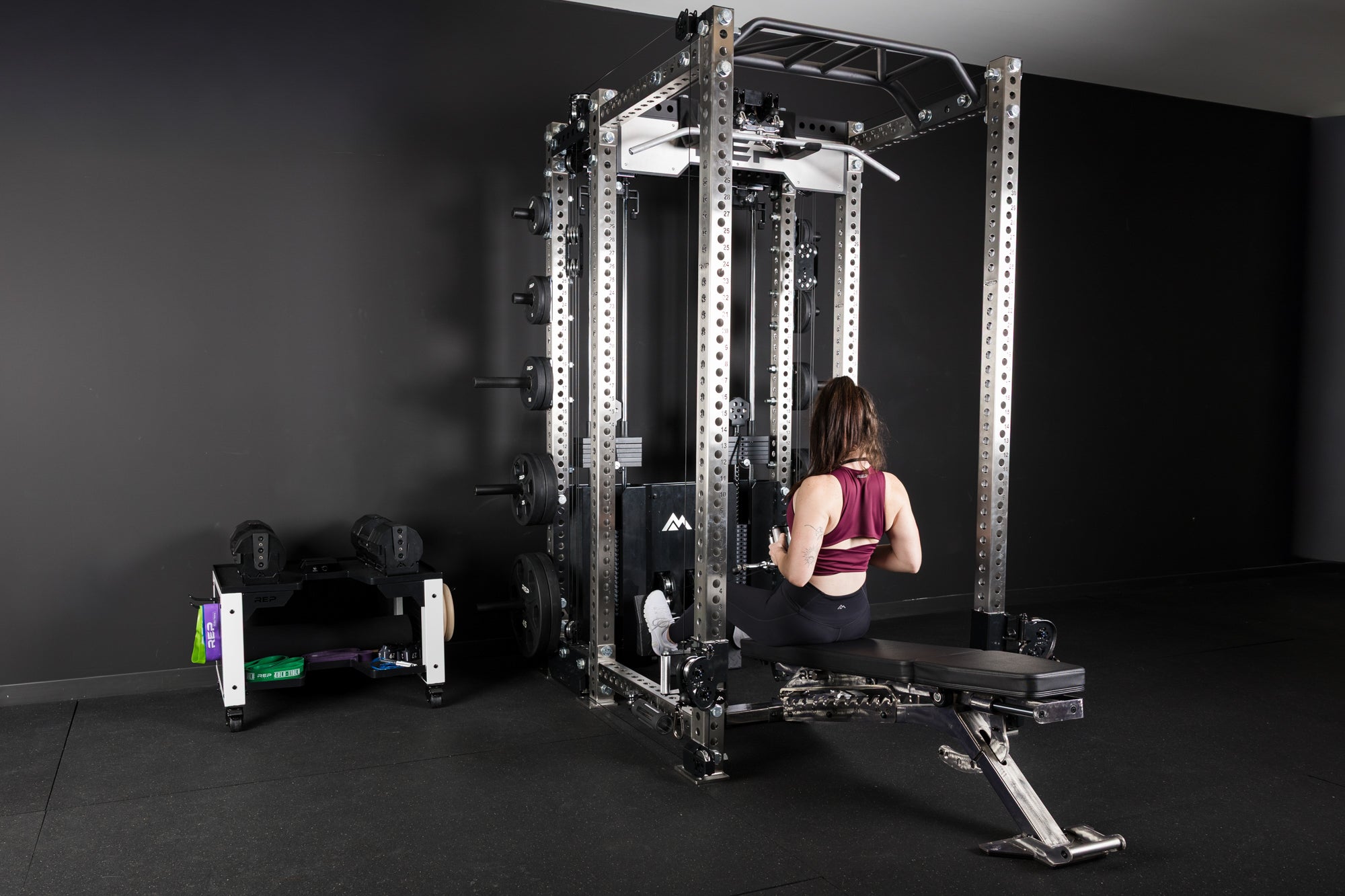 An athlete doing low cable rows on a BlackWing adjustable bench set to a negative angle