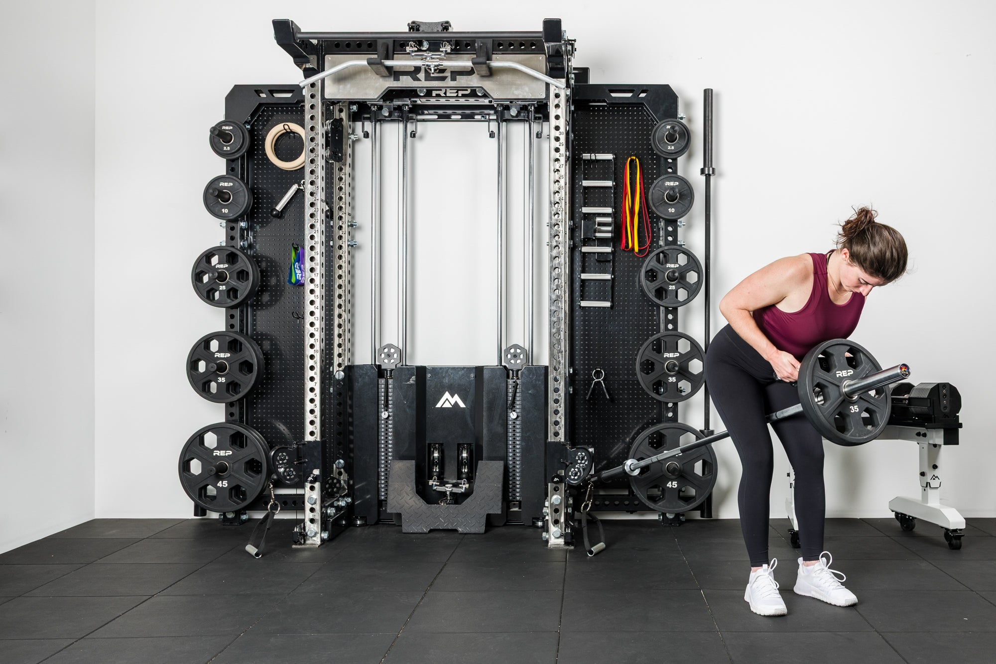 An athlete doing landmine rows with the REP® x Kleva Built® Adroit Landmine attached to the Wall-Mounted Ares 2.0
