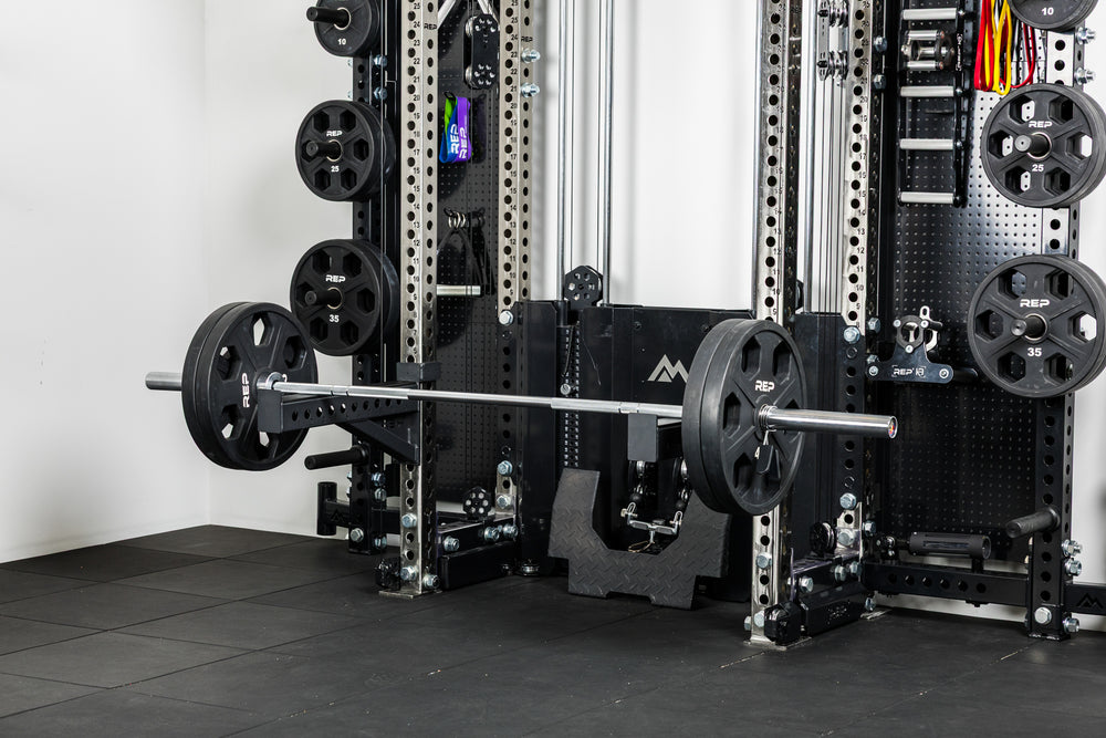 The Colorado barbell loaded with Equalizer™ Urethane-Coated Plates resting on spotter arms off the front of the Wall-Mounted Ares 2.0