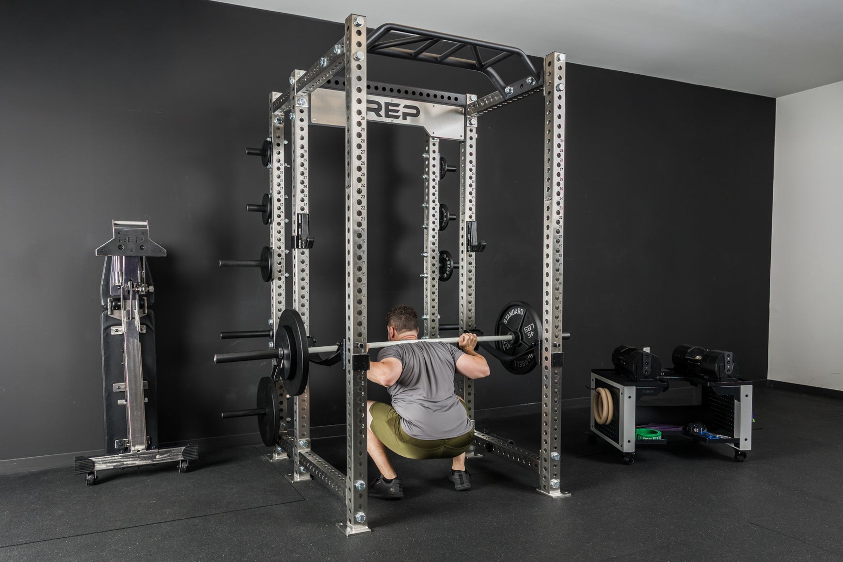 An athlete doing back squats with the Colorado barbell and old school iron weight plates