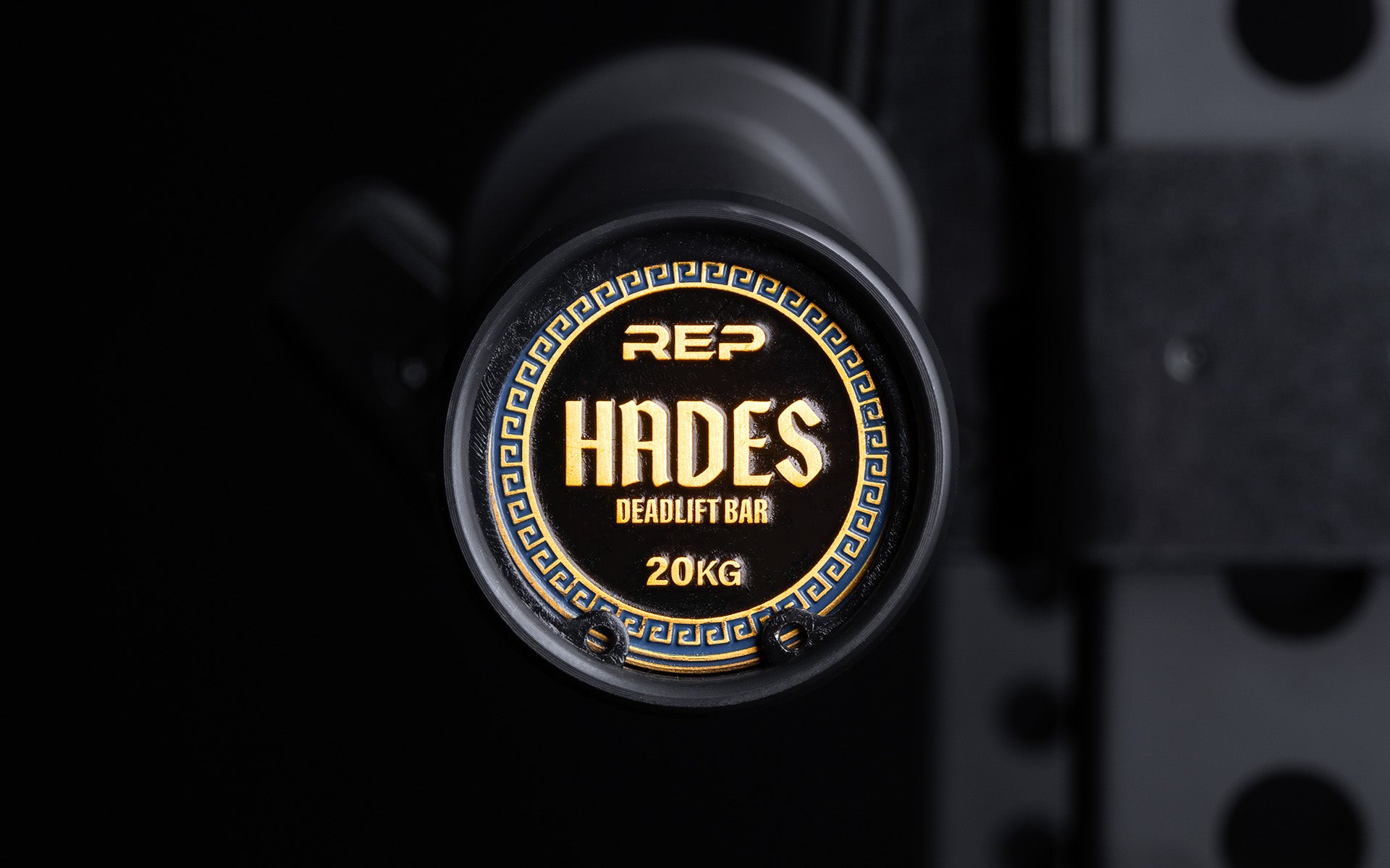 Close-up view of the uniquely designed metal endcap of a racked REP Hades Deadlift Bar.