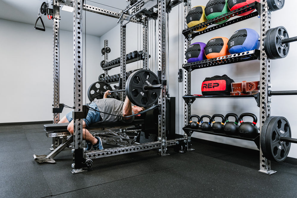 Off-Rack Storage - showing a dual-sided configuration. 41" Shelves coming off the right side and 72" off of the left side. Storage shelves holding dumbbells, medicine balls, weight belt, kettlebells, and small accessories