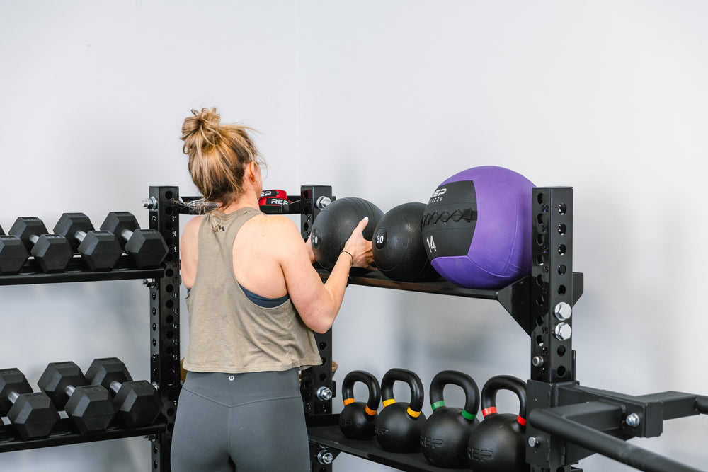 Stand-Alone Modular Storage Sytem  in use - Someone grabbing a slam ball off of the Ball & Plate Storage Shelf