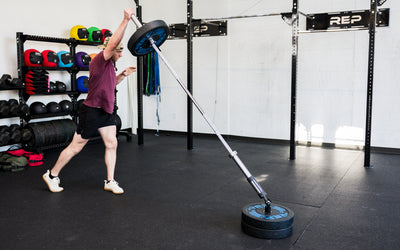 An athlete performing standing presses with the Free Standing REP® x Kleva Built® Adroit Landmine