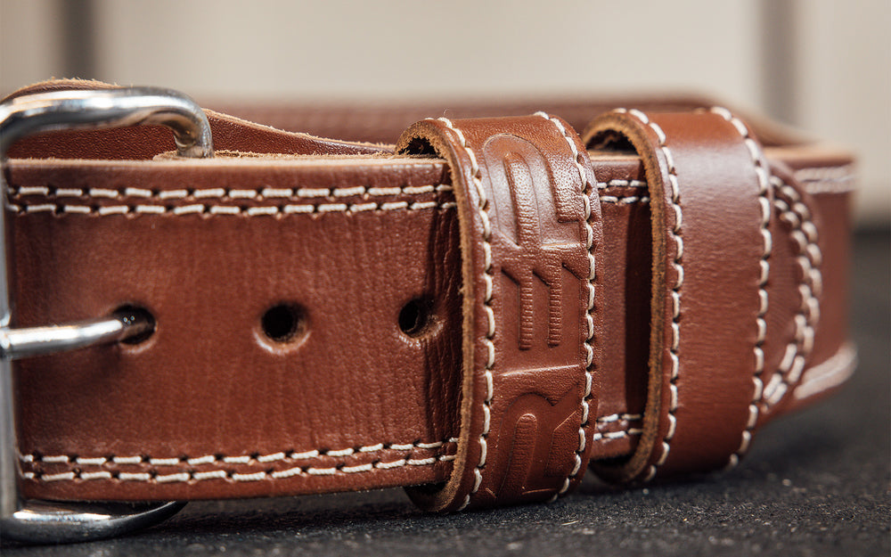 Close-up view of the belt loop and buckle portion of the brown REP Leather Olympic Lifting Belt.